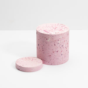 Two pink cylindrical containers with a speckled pattern on a white background